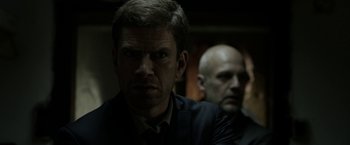 Movie still from “Department Q: The Keeper of Lost Causes” (2013), directed by Mikkel Nørgaard – A man in a suit and tie next to another man in a suit and tie; Close Up shot, Over the shoulder angle