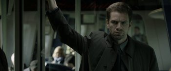 Movie still from “Department Q: The Keeper of Lost Causes” (2013), directed by Mikkel Nørgaard – A man in a black jacket is raising his hand; Close Up shot, Low angle
