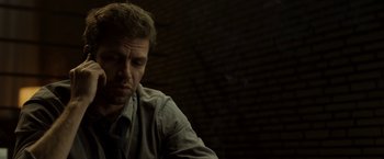 Movie still from “Department Q: The Keeper of Lost Causes” (2013), directed by Mikkel Nørgaard – A person sitting in front of a brick wall; Close Up shot, Low angle