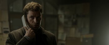 Movie still from “Department Q: The Keeper of Lost Causes” (2013), directed by Mikkel Nørgaard – A person wearing a suit and tie; Close Up shot, Over the shoulder angle