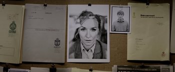 Movie still from “Department Q: The Keeper of Lost Causes” (2013), directed by Mikkel Nørgaard – A picture of a woman in a suit hanging on a wall; Extreme Close Up shot, High angle