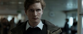 Movie still from “Department Q: The Keeper of Lost Causes” (2013), directed by Mikkel Nørgaard – A person wearing a suit and tie; Close Up shot, Over the shoulder angle