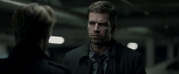 Movie still from “Department Q: The Keeper of Lost Causes” (2013), directed by Mikkel Nørgaard – A person wearing a suit and tie; Close Up shot, Over the shoulder angle