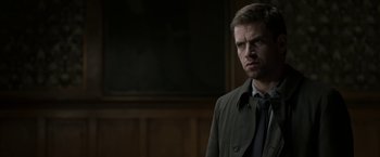 Movie still from “Department Q: The Keeper of Lost Causes” (2013), directed by Mikkel Nørgaard – A man standing in front of a wooden wall; Close Up shot, Over the shoulder angle