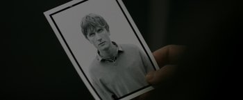 Movie still from “Department Q: The Keeper of Lost Causes” (2013), directed by Mikkel Nørgaard – A person holding a picture of a man; Extreme Close Up shot, High angle