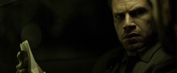 Movie still from “Department Q: The Keeper of Lost Causes” (2013), directed by Mikkel Nørgaard – A person in a dark room; Close Up shot, Over the shoulder angle