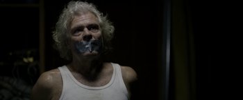 Movie still from “Department Q: The Keeper of Lost Causes” (2013), directed by Mikkel Nørgaard – A man with his mouth taped shut is in a dark room; Close Up shot, Low angle