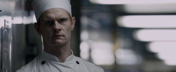 Movie still from “Department Q: The Keeper of Lost Causes” (2013), directed by Mikkel Nørgaard – A person wearing a chef's hat; Close Up shot, Low angle