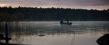 Movie still from “Department Q: The Keeper of Lost Causes” (2013), directed by Mikkel Nørgaard – A man is rowing a boat on a lake; Extreme Wide shot, Low angle