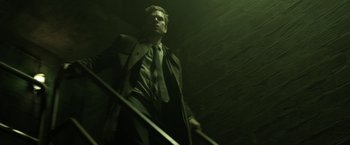 Movie still from “Department Q: The Keeper of Lost Causes” (2013), directed by Mikkel Nørgaard – A man in a suit and tie holding a sword; Medium shot, Low angle