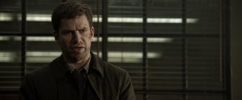 Movie still from “Department Q: The Keeper of Lost Causes” (2013), directed by Mikkel Nørgaard – A person wearing a jacket; Close Up shot, Over the shoulder angle