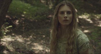 Movie still from “The Keeping Room” (2014), directed by Daniel Barber – A woman with long blonde hair standing in the woods; Close Up shot, Low angle