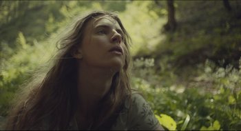 Movie still from “The Keeping Room” (2014), directed by Daniel Barber – A beautiful young lady sitting in the woods; Close Up shot, Low angle