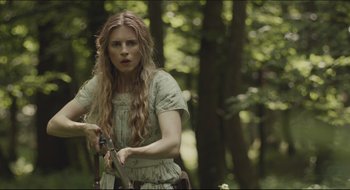 Movie still from “The Keeping Room” (2014), directed by Daniel Barber – A woman holding a sword in a forest; Medium shot, Low angle