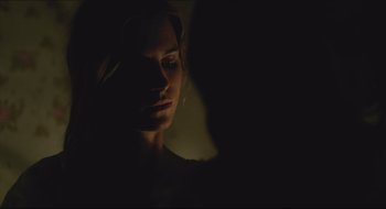 Movie still from “The Keeping Room” (2014), directed by Daniel Barber – A woman is looking at the camera in the dark; Close Up shot, Over the shoulder angle