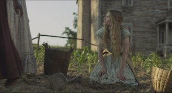 Movie still from “The Keeping Room” (2014), directed by Daniel Barber – A woman kneeling down next to a bucket in a field; Medium shot, Low angle