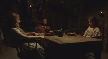 Movie still from “The Keeping Room” (2014), directed by Daniel Barber – A group of people sitting at a table with plates; Medium shot, Over the shoulder angle