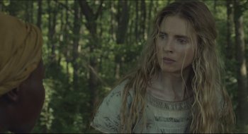 Movie still from “The Keeping Room” (2014), directed by Daniel Barber – A woman with long blonde dreadlocks standing in the woods; Close Up shot, Low angle