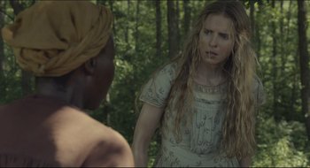 Movie still from “The Keeping Room” (2014), directed by Daniel Barber – A woman standing in front of another woman in a forest; Close Up shot, Over the shoulder angle