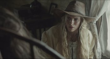 Movie still from “The Keeping Room” (2014), directed by Daniel Barber – A woman with long blonde hair wearing a cowboy hat; Close Up shot, Over the shoulder angle