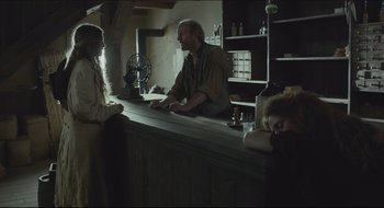Movie still from “The Keeping Room” (2014), directed by Daniel Barber – A man sitting at a bar talking to a woman; Medium shot, Over the shoulder angle