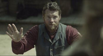 Movie still from “The Keeping Room” (2014), directed by Daniel Barber – A man with a goatee and a vest; Close Up shot, Over the shoulder angle