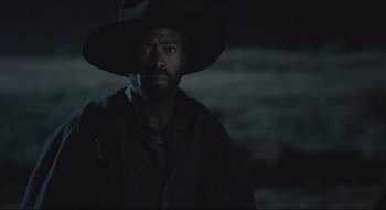 Movie still from “The Keeping Room” (2014), directed by Daniel Barber – A man wearing a hat and a black jacket; Close Up shot, Over the shoulder angle