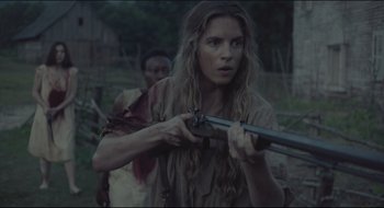 Movie still from “The Keeping Room” (2014), directed by Daniel Barber – A woman is holding a rifle in a field; Medium shot, Over the shoulder angle