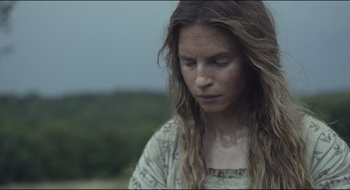 Movie still from “The Keeping Room” (2014), directed by Daniel Barber – A woman with long brown hair is looking down; Close Up shot, Low angle