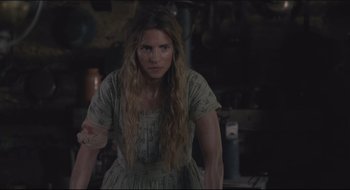 Movie still from “The Keeping Room” (2014), directed by Daniel Barber – A woman with long blonde hair standing in a dark room; Medium shot, Over the shoulder angle