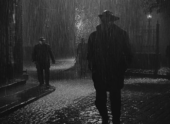 Movie still from “The Keys of the Kingdom” (1944), directed by John M. Stahl – Two men walking in the rain in the dark; Wide shot, High angle