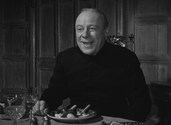 Movie still from “The Keys of the Kingdom” (1944), directed by John M. Stahl – An older man sitting at a table with a plate of food in front of him; Medium shot, High angle