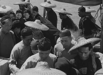Movie still from “The Keys of the Kingdom” (1944), directed by John M. Stahl – A black and white photo of a group of people wearing hats; Medium shot, High angle