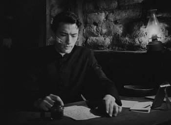 Movie still from “The Keys of the Kingdom” (1944), directed by John M. Stahl – A man sitting at a table writing on a piece of paper; Medium shot, High angle