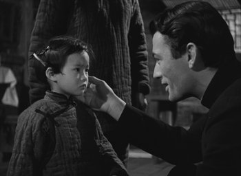 Movie still from “The Keys of the Kingdom” (1944), directed by John M. Stahl – An old photo of a man touching a young boy's face; Medium shot, Over the shoulder angle