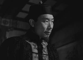 Movie still from “The Keys of the Kingdom” (1944), directed by John M. Stahl – A man wearing a black hat and a black robe; Close Up shot, Low angle