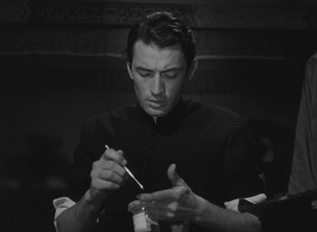 Movie still from “The Keys of the Kingdom” (1944), directed by John M. Stahl – A black - and - white photo of a man holding a pen; Close Up shot, Low angle