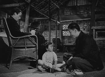 Movie still from “The Keys of the Kingdom” (1944), directed by John M. Stahl – A group of people sitting on the ground; Wide shot, High angle