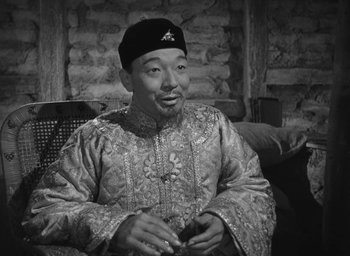Movie still from “The Keys of the Kingdom” (1944), directed by John M. Stahl – An older man wearing a black hat and a robe; Medium shot, High angle