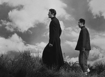 Movie still from “The Keys of the Kingdom” (1944), directed by John M. Stahl – Two men are standing on a hill looking at the sky; Wide shot, Low angle