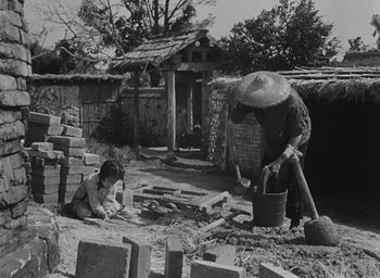Movie still from “The Keys of the Kingdom” (1944), directed by John M. Stahl – An old photo of a man and a little girl working on a house; Wide shot, High angle