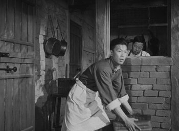 Movie still from “The Keys of the Kingdom” (1944), directed by John M. Stahl – An old photo of a man working in a brick oven; Medium shot, Low angle