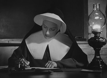 Movie still from “The Keys of the Kingdom” (1944), directed by John M. Stahl – A nun is writing on a piece of paper; Medium shot, Low angle