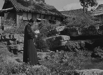 Movie still from “The Keys of the Kingdom” (1944), directed by John M. Stahl – An old photo of a man reading a book outside; Wide shot, Low angle