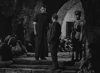 Movie still from “The Keys of the Kingdom” (1944), directed by John M. Stahl – A group of men standing next to each other on some steps; Wide shot, Over the shoulder angle