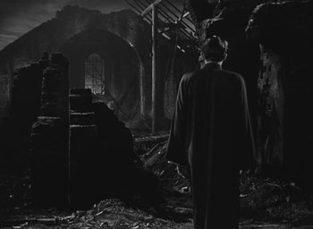 Movie still from “The Keys of the Kingdom” (1944), directed by John M. Stahl – A man standing in the middle of an abandoned building; Wide shot, Low angle