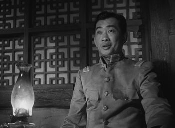 Movie still from “The Keys of the Kingdom” (1944), directed by John M. Stahl – A man in a uniform standing in front of a wall; Medium shot, Low angle