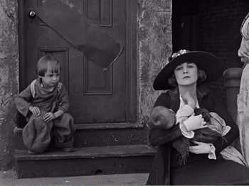 Movie still from “The Kid” (1921), directed by Charles Chaplin – An old photo of a woman and a boy; Medium shot, Low angle