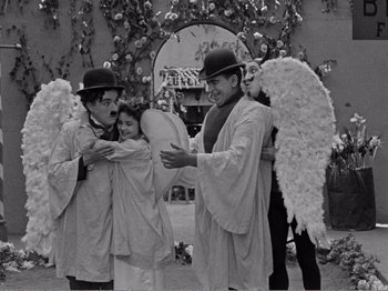 Movie still from “The Kid” (1921), directed by Charles Chaplin – A group of people dressed up as angels; Medium shot, High angle