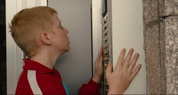 Movie still from “The Kid with a Bike” (2011), directed by Jean-Pierre Dardenne – A young boy is holding on to a wall; Medium shot, Low angle